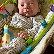 Maverick joined the competition — help win amazing prizes! baby, infant, smile, face, hand, clothing, pattern, baby_seat, toy, pacifier, cushion, colorful, comfort, indoor, portrait, child, young, cute, resting, expression