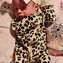 baby, child, infant, sleeping, onesie, leopard_print, headband, bow, blanket, pink, soft, cute, animal_pattern, cozy, napping, clothing, closeup, portrait, indoor, peaceful