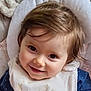 baby, smiling, face, infant, bib, blue_clothing, baby_chair, cushion, hair, eyes, child, cute, portrait, indoors, young_child, happy, head, skin, person, toddler