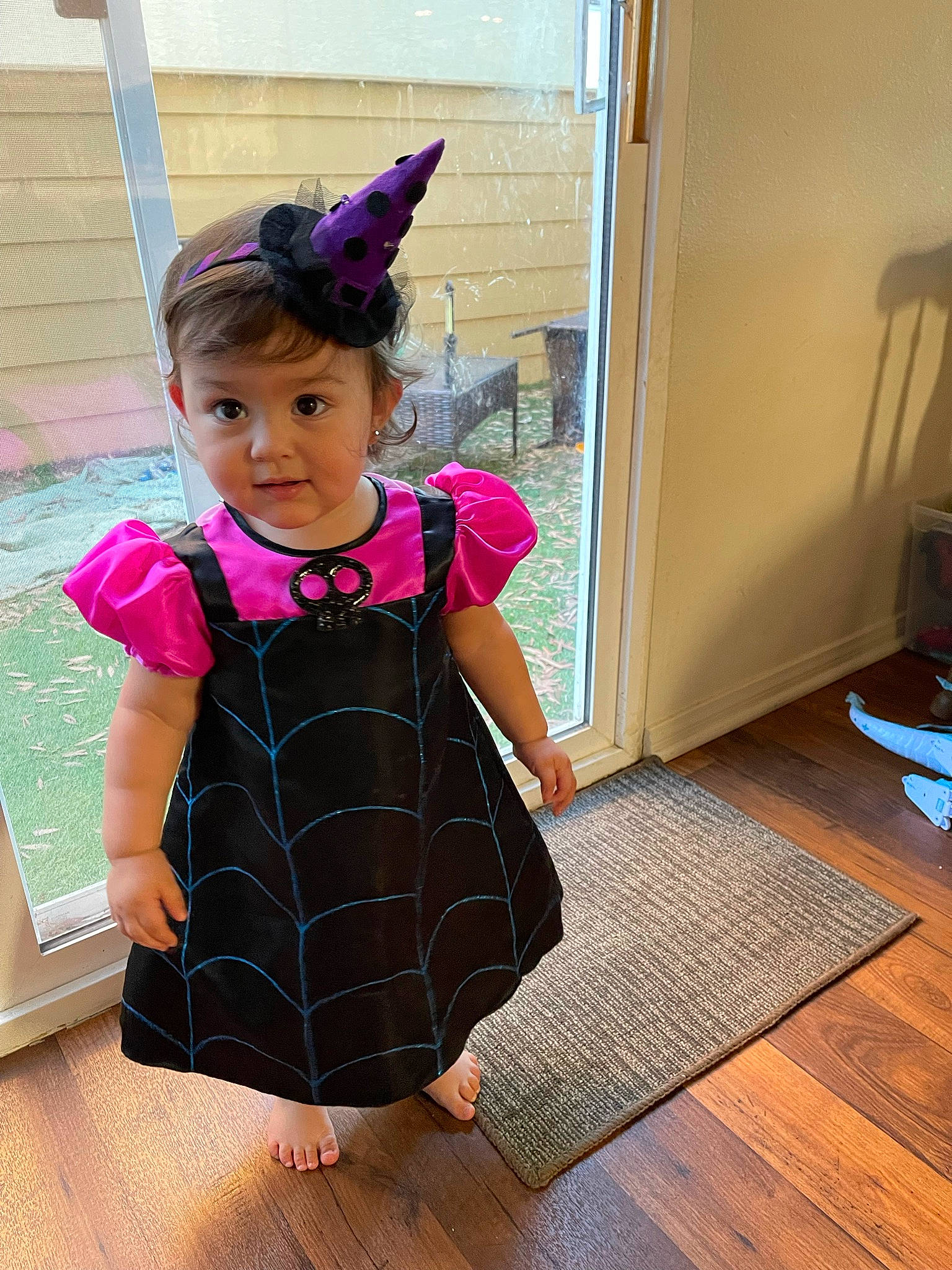 Ellie is registered to the contest to win money with this photo: baby, baby_toddler_clothing, child, costume, day_dress, dress, fashion_accessory, flooring, fun, hair_accessory, happy, hardwood, magenta, pattern, person, play, purple, sleeve, toddler, violet