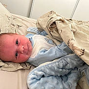 Théo a rejoint le concours — aidez-le/la à gagner de superbes lots ! baby, blanket, bed, butterfly_pattern, child, clothing, comfort, cute, face, infant, laying, pillow, portrait, resting, soft_texture, toddler, wearing, young_child, indoor, sleepwear