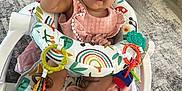 Hennessey joined the competition — help win amazing prizes! baby, child, smiling, pink_dress, headband, baby_chair, toy_rings, blanket, plush_toy, happy, indoor, floor, carpet, footwear_free, person, infant, cute, playful, colorful, portrait