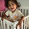baby, bedroom, child, cozy, crib, curly_hair, cute, furniture, ghost, happy, holding, indoor, person, playful, pumpkin, shirt, smile, toddler, white_crib, young_child