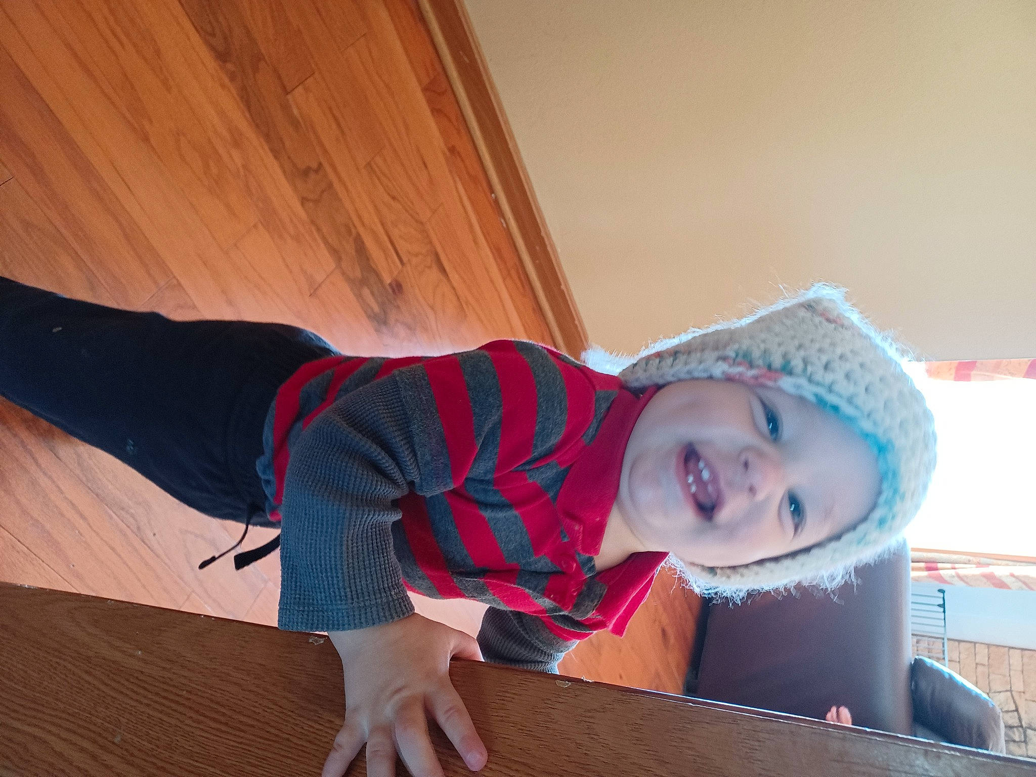Levi is registered to the contest to win money with this photo: baby_toddler_clothing, child, comfort, elbow, flooring, fun, happy, hardwood, headwear, human_leg, joy, knee, person, room, sitting, sleeve, smile, standing, t_shirt, thigh