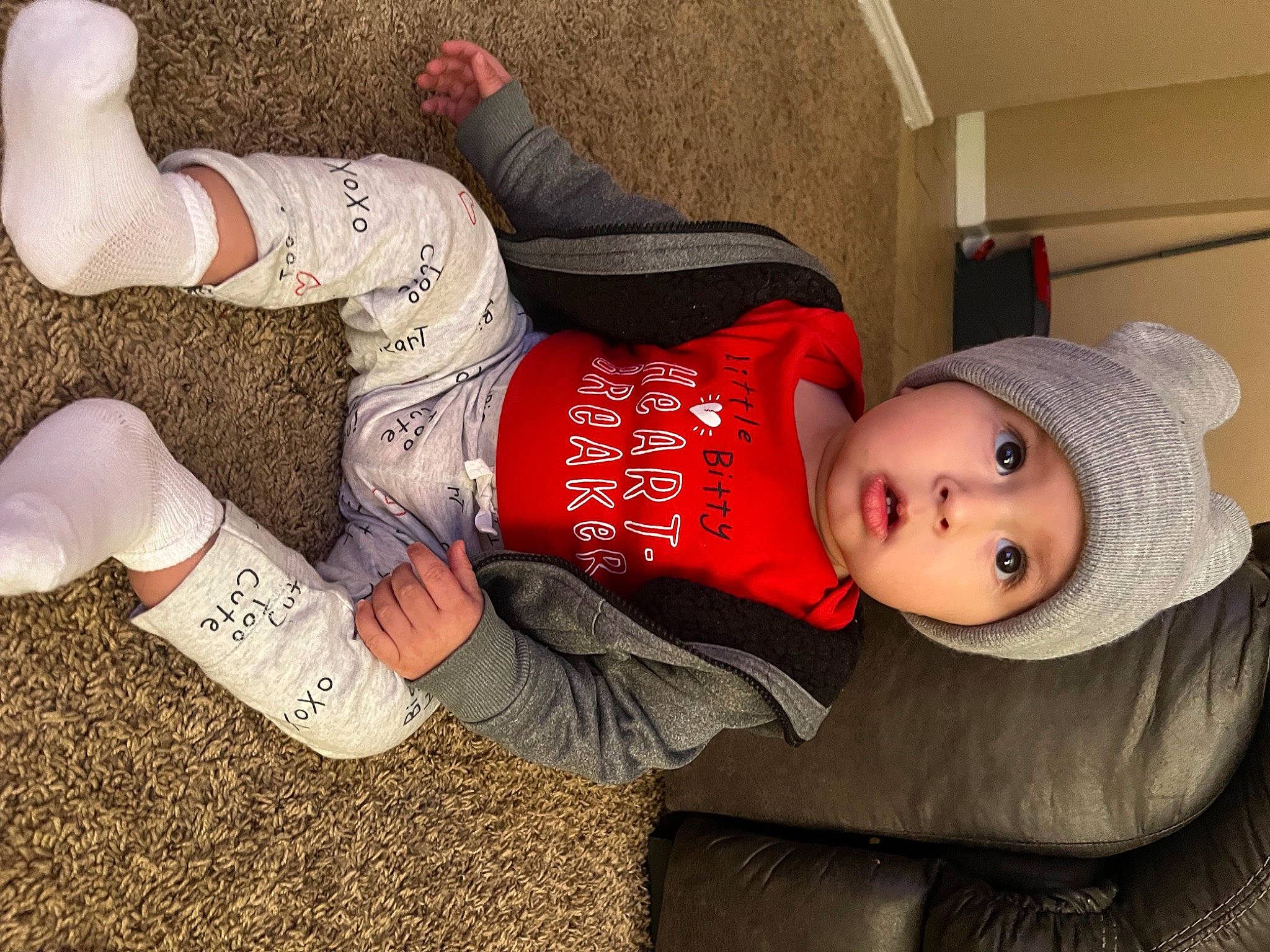 Noah is registered to the contest to win money with this photo: baby, baby_toddler_clothing, carmine, child, comfort, costume_hat, foot, grass, hat, headwear, human_leg, knee, lap, person, sitting, sleeve, sock, soil, surprise, thigh