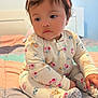 Daniela is registered to the contest to win money with this photo: baby, child, girl, headband, bow, onesie, floral_pattern, bed, quilt, pajamas, earrings, indoors, cute, sitting, portrait, soft_lighting, bedroom, person, infant, sleepwear
