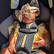 Sparsha joined the competition — help win amazing prizes! baby, bow, car_seat, child, chubby_arms, chubby_legs, closeup, cute, headband, indoor, infant, person, resting, safety_harness, seatbelt, sleeping, sunlight, toddler, warning_label, yellow_clothing