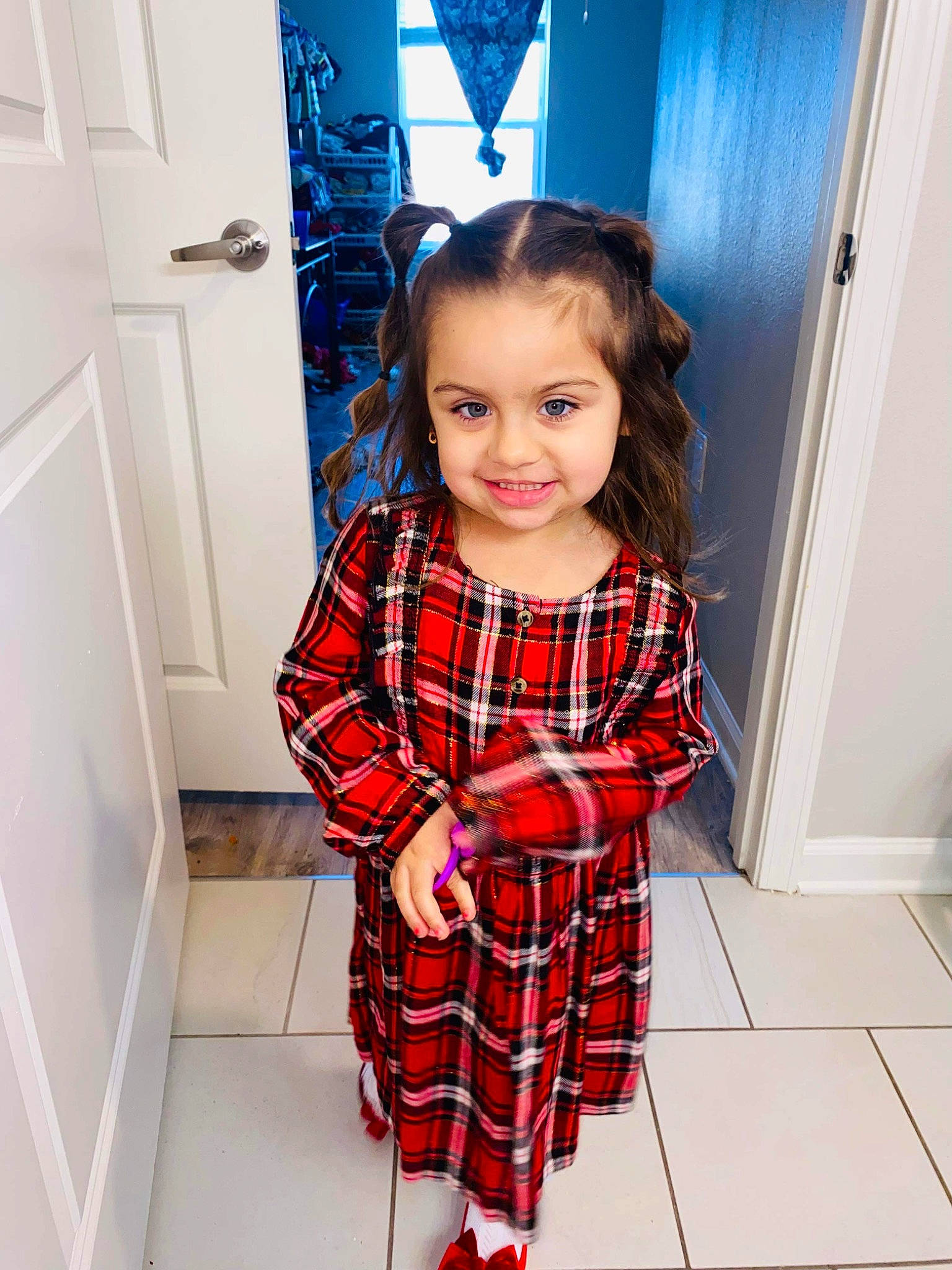 Addilyn joined the competition — help win amazing prizes! baby_toddler_clothing, blue, collar, door, dress, fashion_design, flooring, hair, happy, joy, knee, long_hair, pattern, person, plaid, shoulder, sleeve, smile, standing, tartan