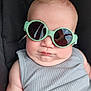 baby, child, sunglasses, green_sunglasses, tank_top, gray_clothing, chubby_cheeks, reflection, person, portrait, close_up, fashion, cool, cute, infant, seated, black_background, skin, head, face