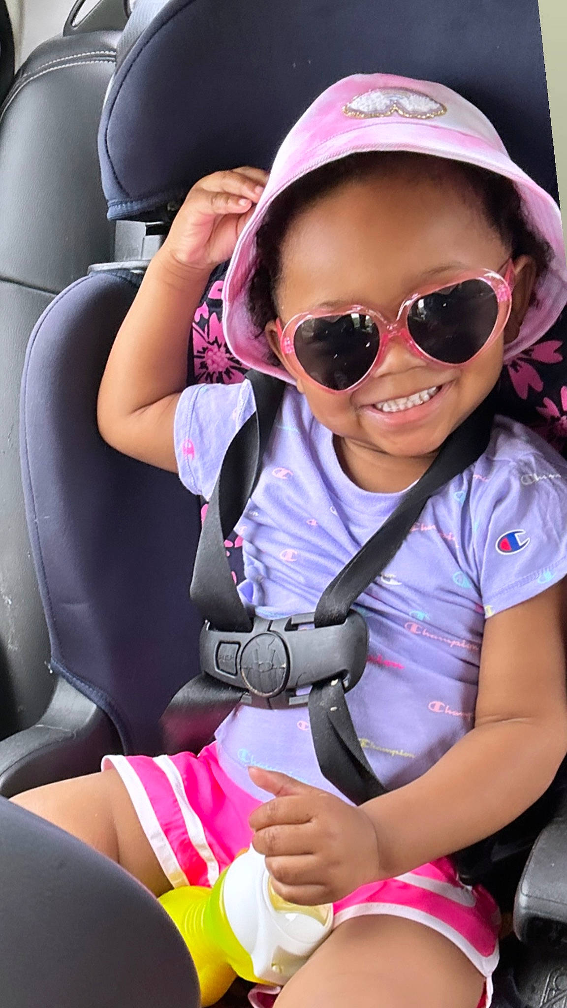 Jalaya is registered to the contest to win money with this photo: auto_part, automotive_design, baseball_cap, cap, car_seat, cool, eyewear, fun, glasses, goggles, happy, joy, leisure, person, personal_protective_equipment, pink, smile, sunglasses, toddler, travel