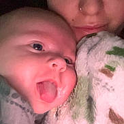 Hayes joined the competition — help win amazing prizes! baby, infant, person, adult, blanket, selfie, tongue_out, cuddle, cozy, portrait, close_up, indoor, low_light, cheek, nose_ring, eyes, mouth, bedding, sleepy, family