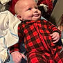 Hayes joined the competition — help win amazing prizes! baby, infant, plaid_pajamas, red_black_pattern, dimple, smile, laying_down, blanket, bedding, laundry_pile, cup, pacifier, hand, onesie, portrait, indoors, cozy, soft_toys, cloth, person