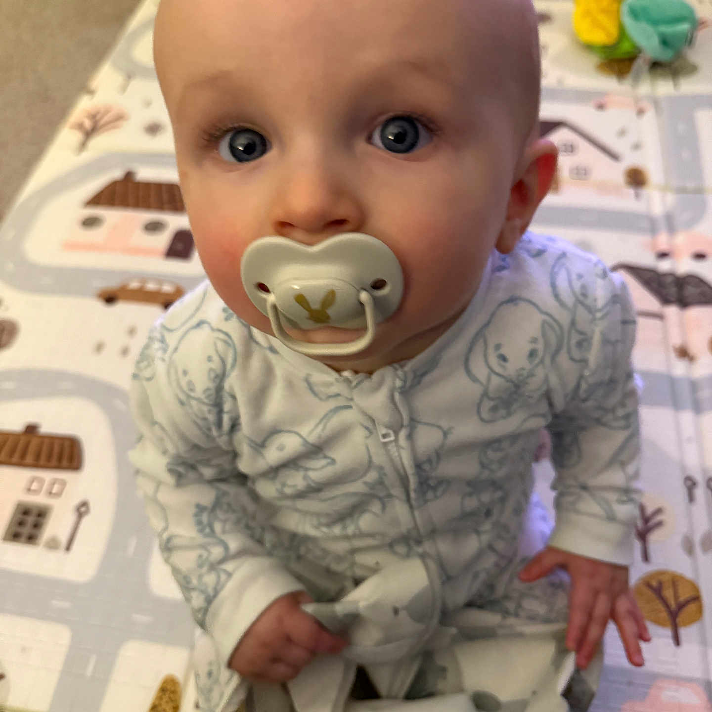 Niall joined the competition — help win amazing prizes! baby, blue_eyes, carpet, child, curious, cute, face, floor, hands, head, home, indoor, infant, pacifier, pajamas, patterned_clothing, playmat, sitting, toy, young_child