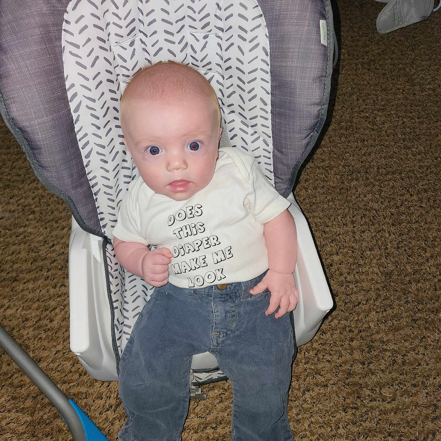 Nakota joined the competition — help win amazing prizes! baby, infant, child, baby_seat, clothing, shirt, carpet, indoor, person, cute, expression, seat, pattern, blue_eyes, pants, footwear, hand, face, young, curious