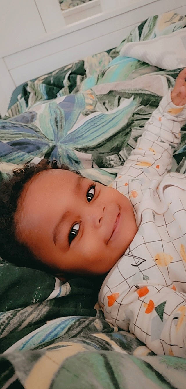 Saleem is registered to the contest to win money with this photo: baby, bedding, cheek, child, eyelash, fashion_accessory, forehead, grass, joy, leaf, linens, mouth, organ, pattern, person, plant, portrait_photography, smile, textile, toddler