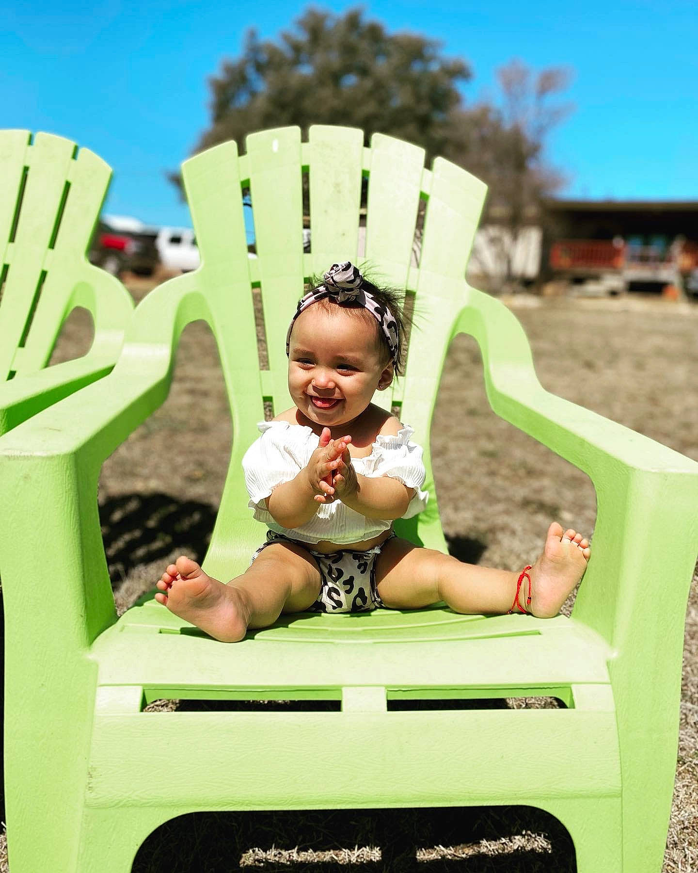 Evelyn is registered to the contest to win money with this photo: baby, child, city, flash_photography, fun, grass, green, happy, jewellery, joy, leisure, outdoor_play_equipment, person, personal_protective_equipment, play, recreation, sitting, sky, smile, toddler
