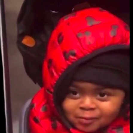 Lycia participe au concours pour gagner de l'argent avec cette photo : child, face, hood, jacket, red, black, smile, indoor, clothing, young, person, cute, warm, peeking, portrait, expression, winterwear, seated, hoodie, playful