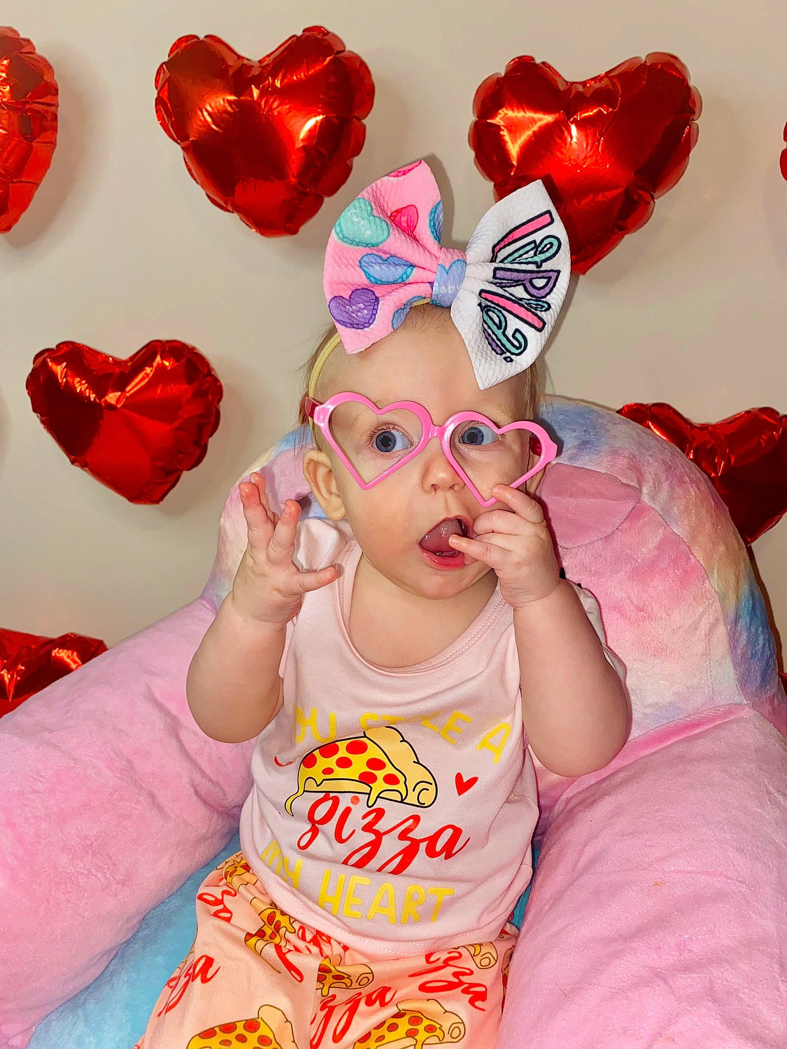 Lorelai is registered to the contest to win money with this photo: baby, baby_toddler_clothing, carmine, child, event, eyewear, fashion_accessory, finger, fun, gesture, glasses, hair_accessory, happy, magenta, organ, party_supply, person, pink, red, sunglasses