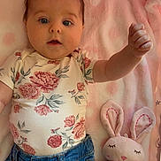 Eloise is registered to the contest to win money with this photo: baby, infant, child, floral_clothing, denim_jeans, pink_blanket, soft_toy, plush_bunny, raised_arm, cute, indoors, portrait, laying_down, happy, face, head, hand, fabric, comfort, childhood