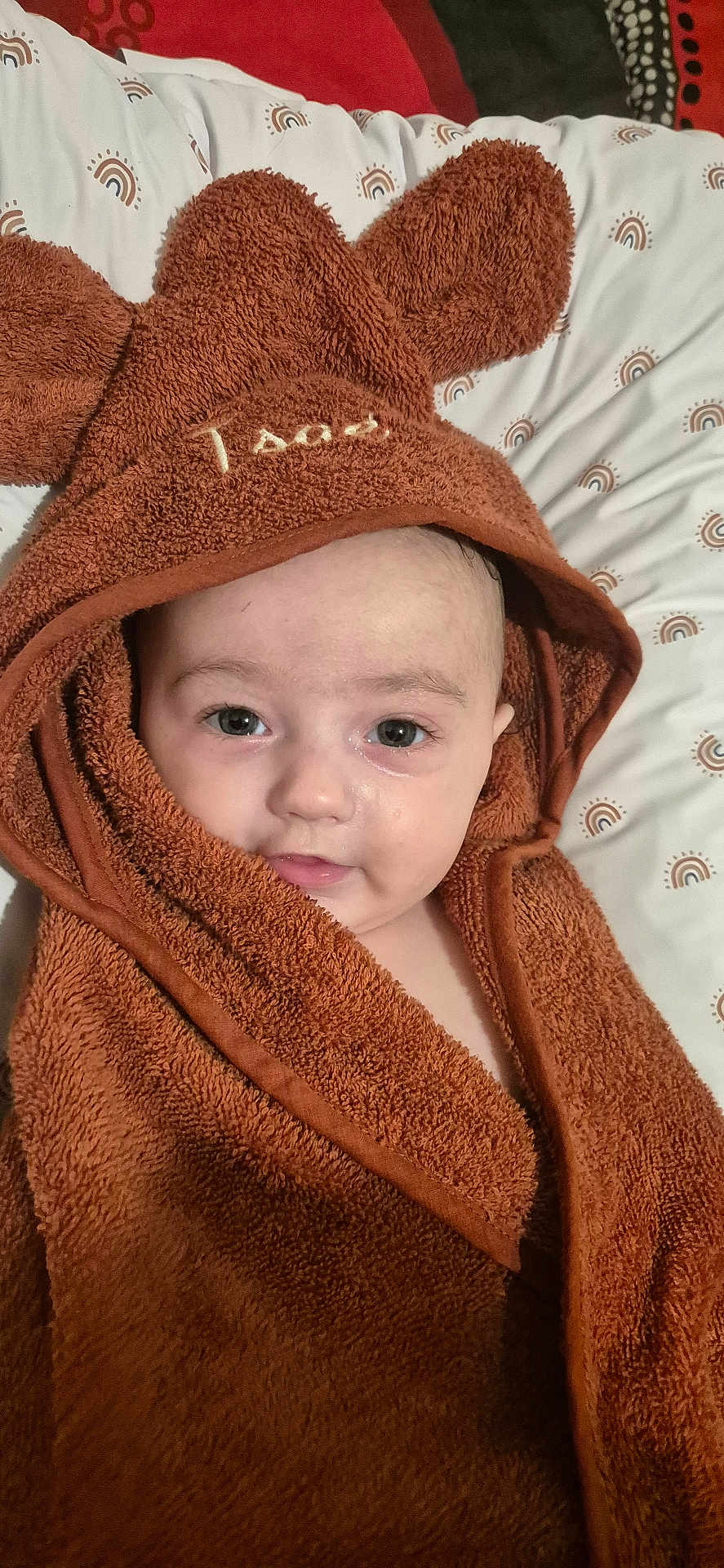 Isaé participe au concours pour gagner de l'argent avec cette photo : baby, towel, brown_towel, face, child, bed, blanket, cute, infant, portrait, eyes, skin, head, expression, indoors, lying_down, fabric, soft_texture, wrapped, cozy