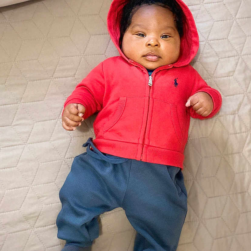 Maël participe au concours pour gagner de l'argent avec cette photo : baby, beige_quilt, blue_pants, casual, child, comfortable, cute, face, feet, hands, hoodie, indoors, infant, lying_down, portrait, quilted_bedspread, red_clothing, sleepwear, socks, soft_lighting