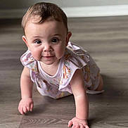 Amelia joined the competition — help win amazing prizes! baby, infant, crawling, floor, wooden_floor, dress, floral_pattern, cute, child, indoors, person, smiling, happy, young, skin, hands, eyes, short_hair, playful, portrait