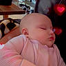 baby, sleeping, pink_clothing, heart_shapes, cozy, indoor, blanket, peaceful, child, portrait, infant, relaxing, cute, soft_light, closeup, face, hand, seated, love, rest
