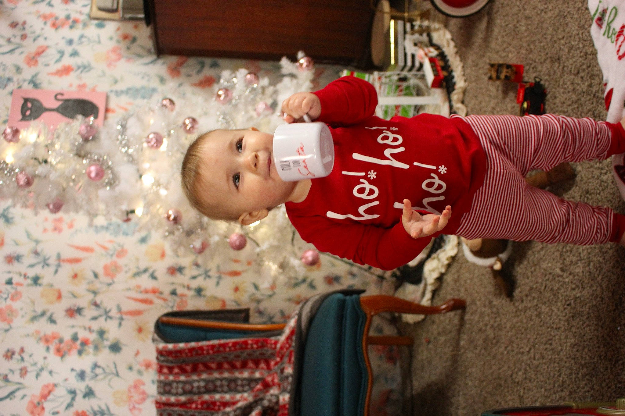 Meredith is registered to the contest to win money with this photo: baby, baby_toddler_clothing, carmine, child, christmas, christmas_eve, christmas_ornament, event, fun, happy, hat, holiday, person, play, red, room, sitting, textile, toddler, tradition