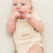 Owen joined the competition — help win amazing prizes! baby, infant, child, onesie, blanket, milestone, wooden_plaque, hand, face, blue_eyes, skin, lying_down, cute, soft_texture, indoors, portrait, fingers, young, expression, resting