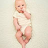 Owen is registered to the contest to win money with this photo: baby, infant, blue_eyes, onesie, lying_down, fluffy_rug, cream_color, hand_in_mouth, curious_expression, skin, foot, head, soft_texture, child, cute, portrait, newborn, resting, indoors, person