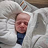 newborn, baby, sleeping, blanket, cushion, baby_seat, face, infant, cozy, indoors, wooden_floor, lamp, peaceful, wrapped, soft, clothing, resting, head, closeup, portrait