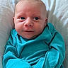 Owen is registered to the contest to win money with this photo: baby, infant, face, blue_clothing, blanket, close_up, portrait, person, newborn, cute, skin, eyes, smile, head, sleepwear, soft_texture, expression, indoor, child, young