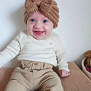 Elaia participe au concours pour gagner de l'argent avec cette photo : baby, child, smiling, headband, knitted, bow, cream_clothing, corduroy_pants, sitting, indoors, happy, cute, portrait, face, blue_eyes, long_sleeves, infant, cozy, neutral_colors, texture