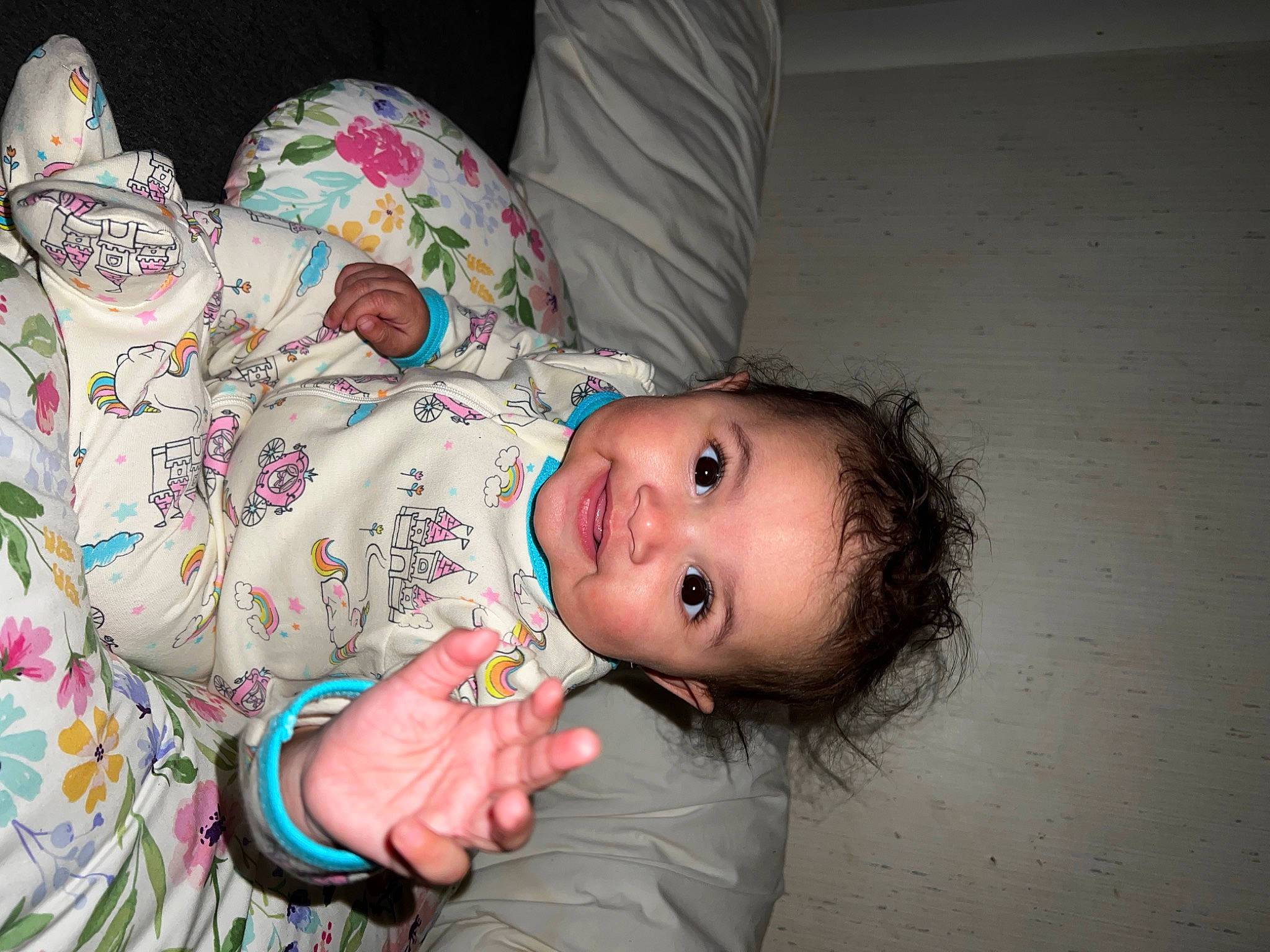 Sienna is registered to the contest to win money with this photo: arm, baby, baby_toddler_clothing, cheek, child, comfort, face, finger, flash_photography, flooring, fun, happy, head, joy, linens, nose, pattern, person, room, sitting