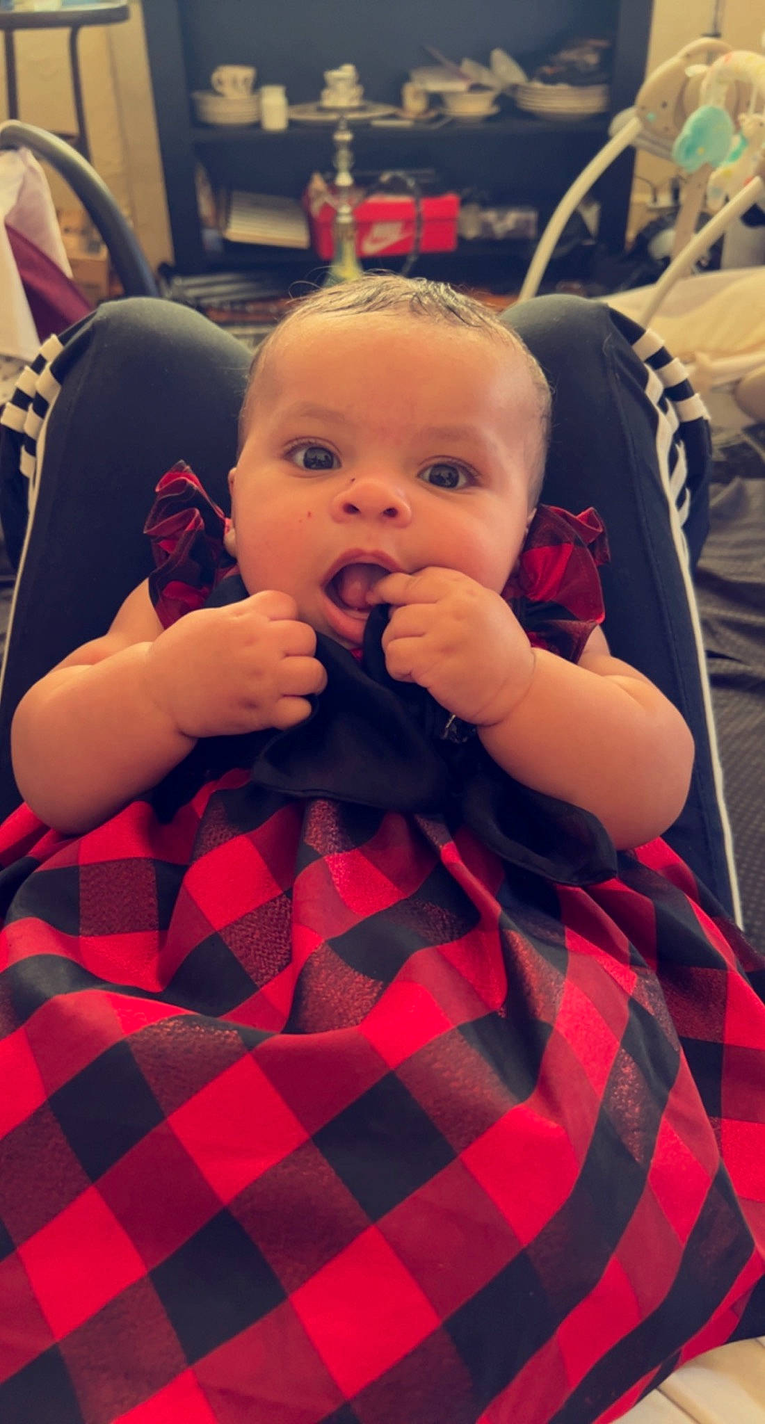 Isabella is registered to the contest to win money with this photo: baby, baby_toddler_clothing, black, chair, cheek, child, collar, comfort, finger, fun, mouth, nail, pattern, person, plaid, red, skin, sleeve, tartan, thumb