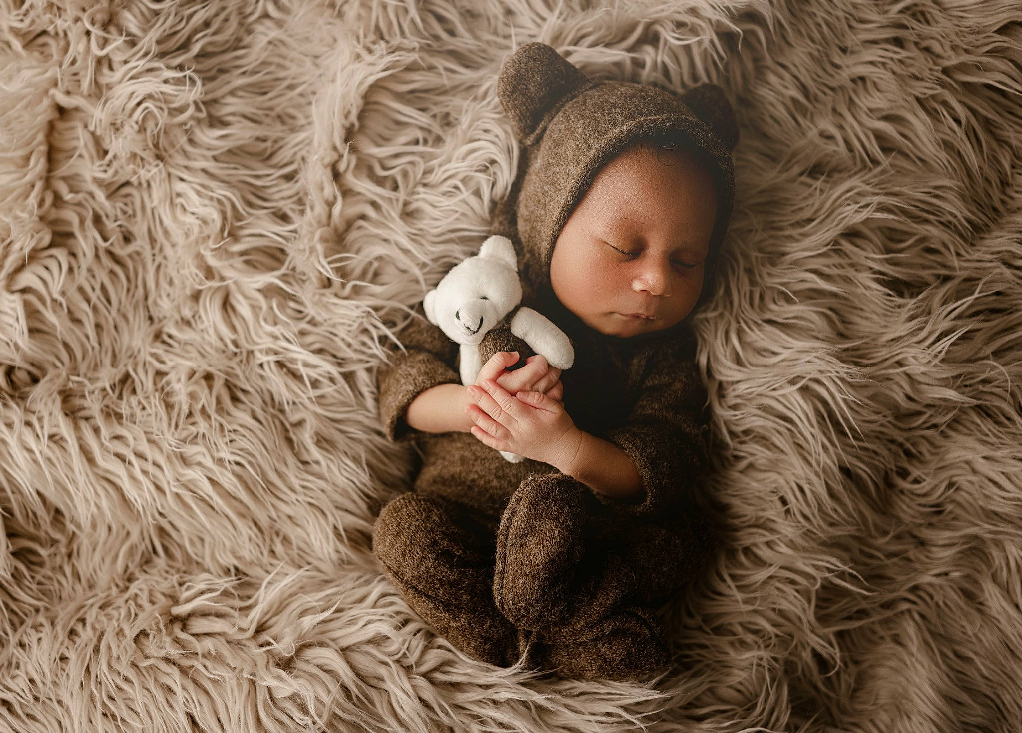 Legend is registered to the contest to win money with this photo: baby, child, comfort, facial_expression, finger, flooring, fur, fur_clothing, grass, hand, outerwear, people_in_nature, person, plant, skin, textile, toddler, toy, tree, wood