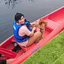 Vanille a rejoint le concours — aidez-le/la à gagner de superbes lots ! person, dog, canoe, water, life_jacket, outdoor, reflection, tree, grass, pet, animal, watercraft, calm, smile, leash, red, blue, casual_clothing, nature, daytime