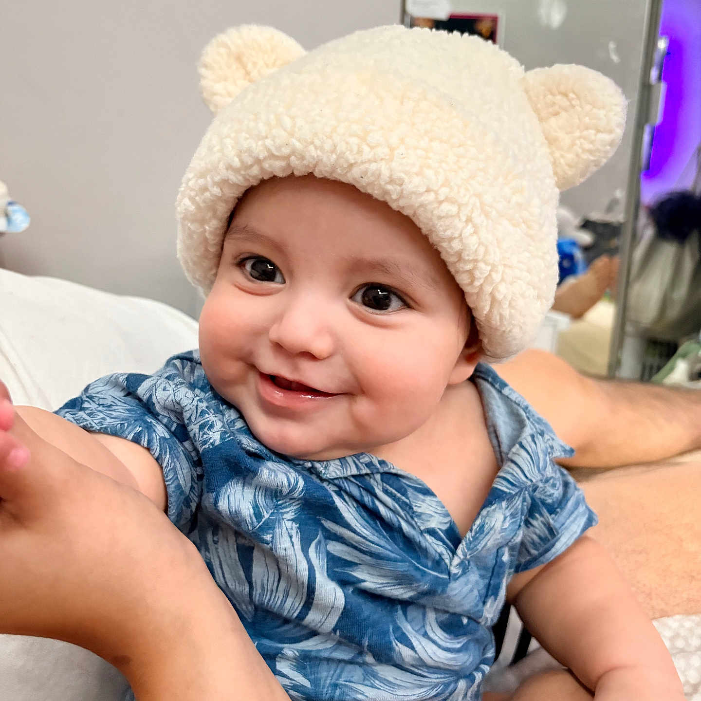 Nyjah is registered to the contest to win money with this photo: arm, baby, baby_fashion, bear_ears, blue_shirt, child, clothing, cute, expression, face, hand, happy, hat, human, indoors, infant, person, portrait, skin, smiling