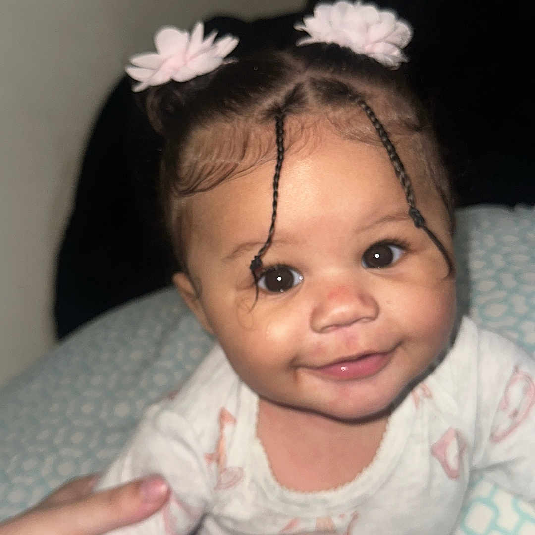 Milaya joined the competition — help win amazing prizes! baby, baby_clothes, braided_hair, child, closeup, cushion, cute, eye, face, hair_ties, hand, happy, indoor, infant, onesie, person, portrait, skin, smiling, young_child