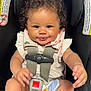 baby, child, car_seat, curly_hair, smile, toy, seatbelt, clothing, infant, cute, sitting, safety, indoor, person, young_child, expression, playful, head, face, hands