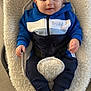 baby, child, blue_hoodie, bouncer_seat, cushion, floor, footwear, happy, indoor, infant, person, portrait, sitting, smile, sock, toddler, white_socks, young_child, zipper, casual_clothing