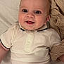 baby, smiling, infant, white_shirt, diaper, blanket, lying_down, cute, happy, child, face, skin, head, eyes, mouth, clothing, indoors, person, newborn, toddler