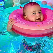 Camille a rejoint le concours — aidez-le/la à gagner de superbes lots ! baby, blue, child, colorful, cute, face, floating, fun, happy, indoor, infant, inflatable_ring, pink, playful, pool, smiling, splash, swimming, toy, water