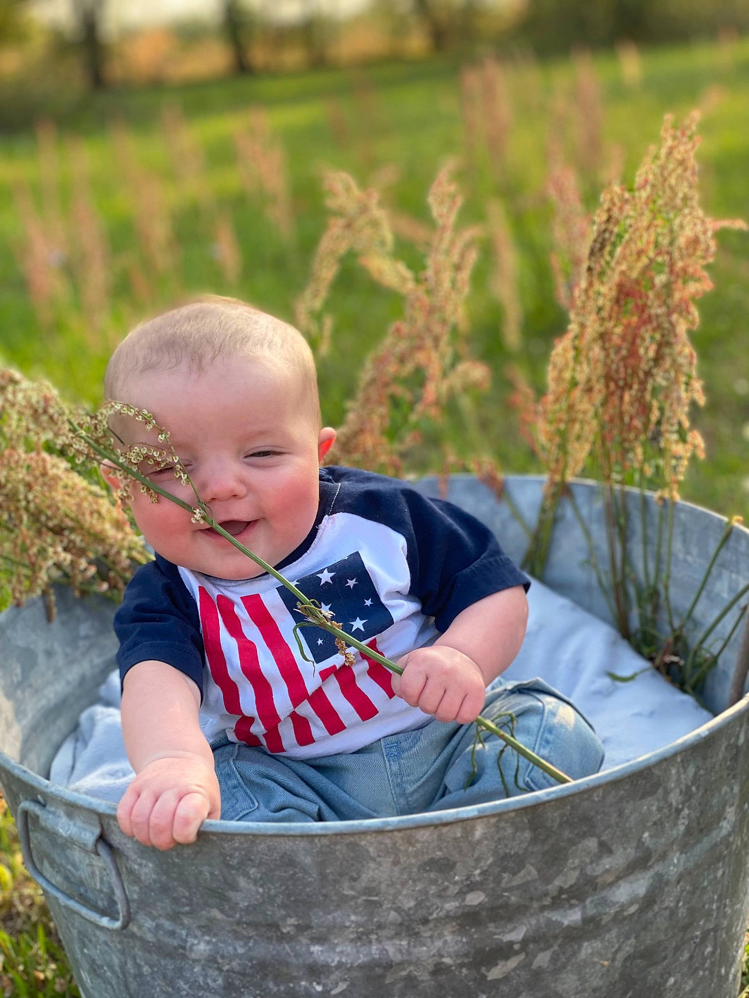 Braylen is registered to the contest to win money with this photo: automotive_tire, baby, baby_toddler_clothing, child, circle, fun, garden, grass, grass_family, grassland, happy, leisure, people_in_nature, person, photograph, plant, prairie, sitting, tire, toddler