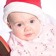 Darcie joined the competition — help win amazing prizes! baby, child, face, santa_hat, pink_clothing, candy_cane_pattern, heart_pattern, holiday, christmas, festive, cute, infant, portrait, closeup, smiling, soft_lighting, indoors, person, headwear, holiday_season