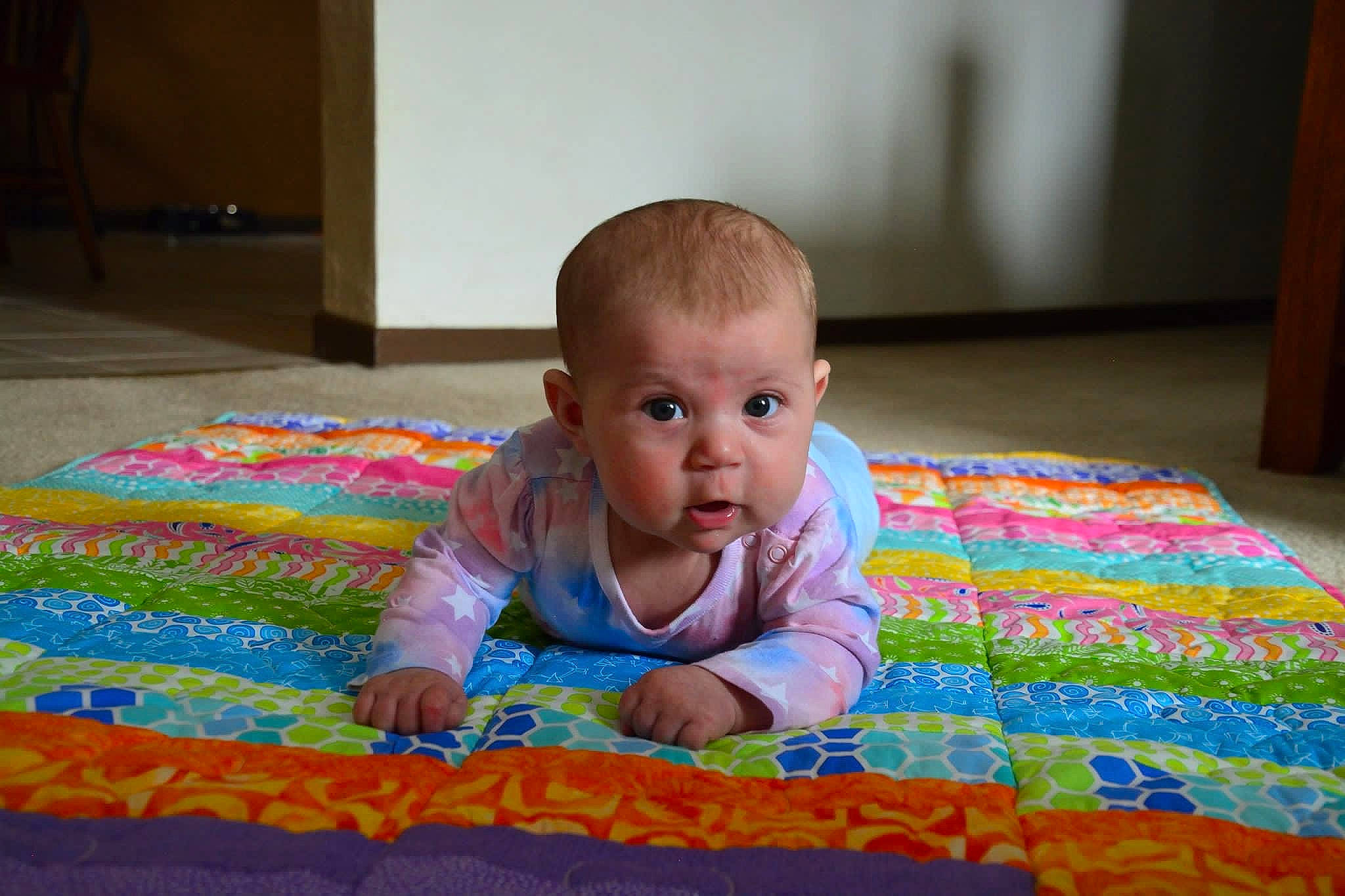 Evelynn joined the competition — help win amazing prizes! baby, baby_toddler_clothing, cheek, comfort, crawling, eye, floor, flooring, fun, grass, hardwood, head, leisure, linens, person, sitting, skin, textile, toddler, tummy_time