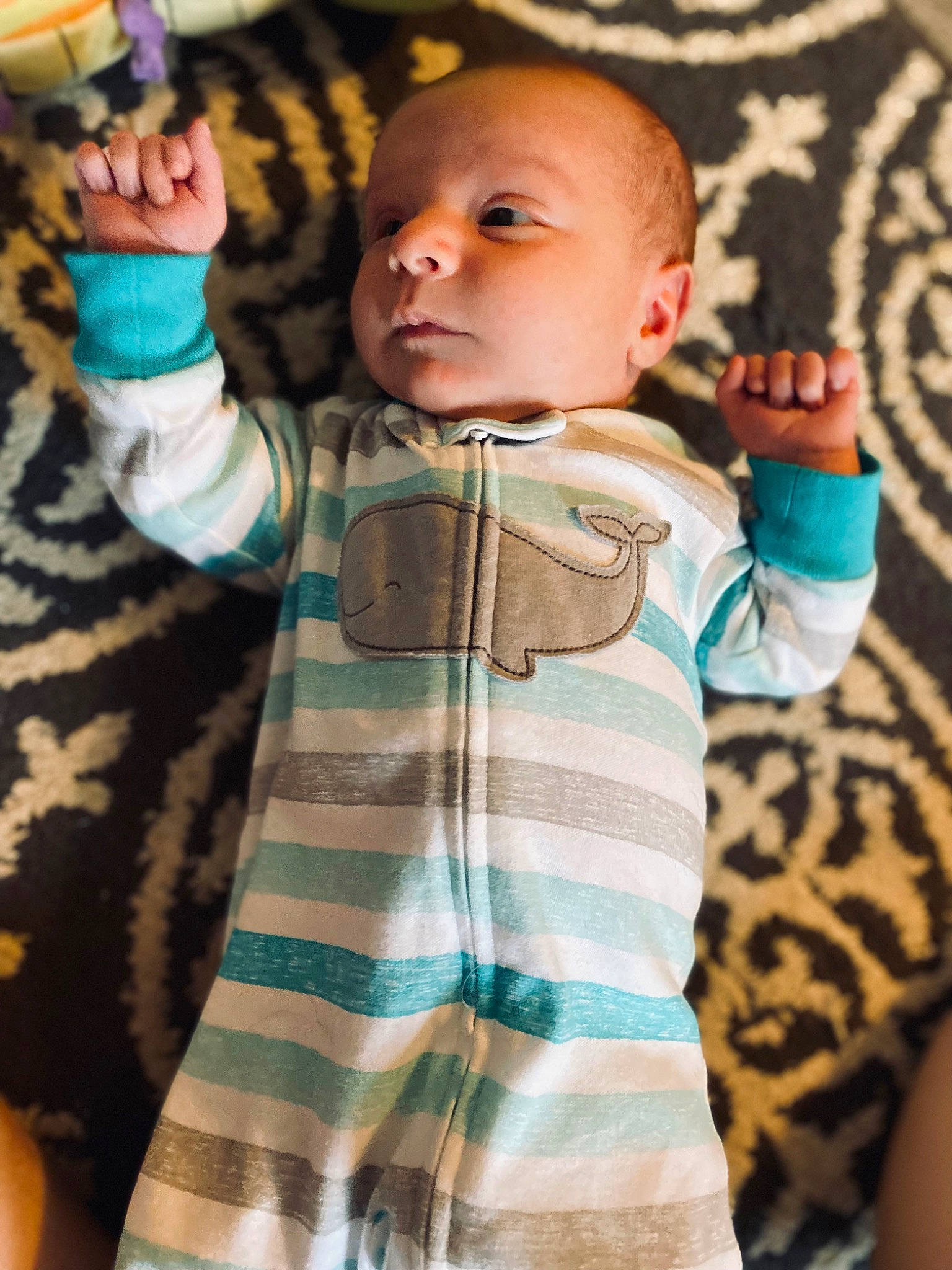 Lawrence is registered to the contest to win money with this photo: arm, baby, baby_toddler_clothing, child, cool, couch, face, finger, gesture, hand, happy, head, joint, neck, pattern, person, shoulder, sleeve, t_shirt, textile