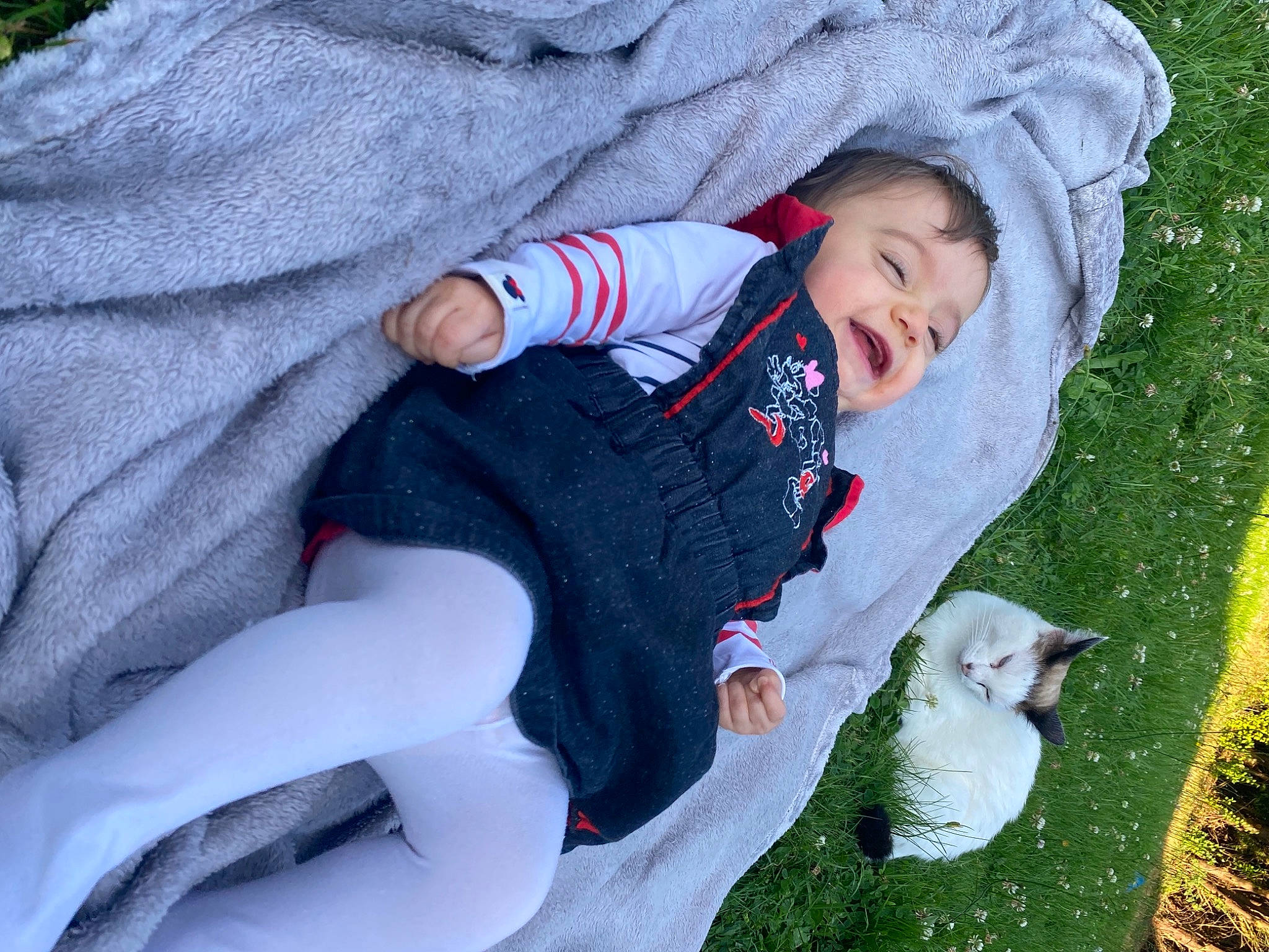 Lëyna a rejoint le concours — aidez-le/la à gagner de superbes lots ! baby, baby_toddler_clothing, comfort, grass, grey, hand, happy, head, human_body, lap, lawn, leaf, mammal, people_in_nature, person, plant, sleeve, smile, toddler, tree