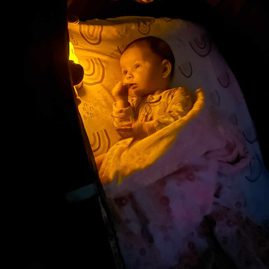Kaycie joined the competition — help win amazing prizes! baby, infant, child, sleeping, blanket, swaddled, bedtime, portrait, face, indoors, low_light, dramatic_lighting, warm_light, cozy, cocoon, newborn, textile, dark_background, close_up, photography