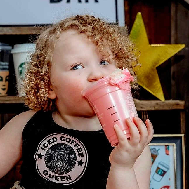 Liliana is registered to the contest to win money with this photo: baby, beverage, blonde, cup, curlyhair, disposablecup, drinking, face, hair, head, person